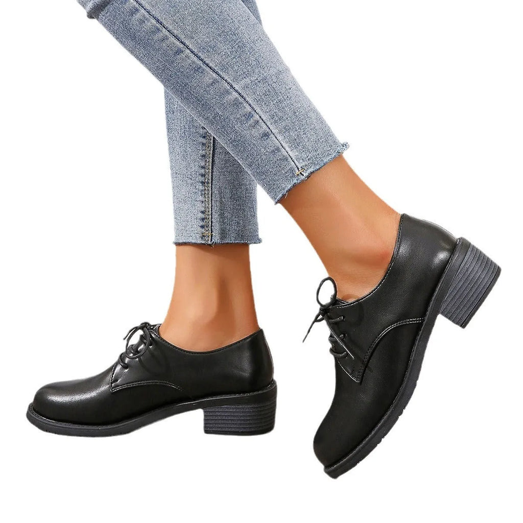 Black women's low-top work shoes with a thick chunky mid-heel and rubber sole.
