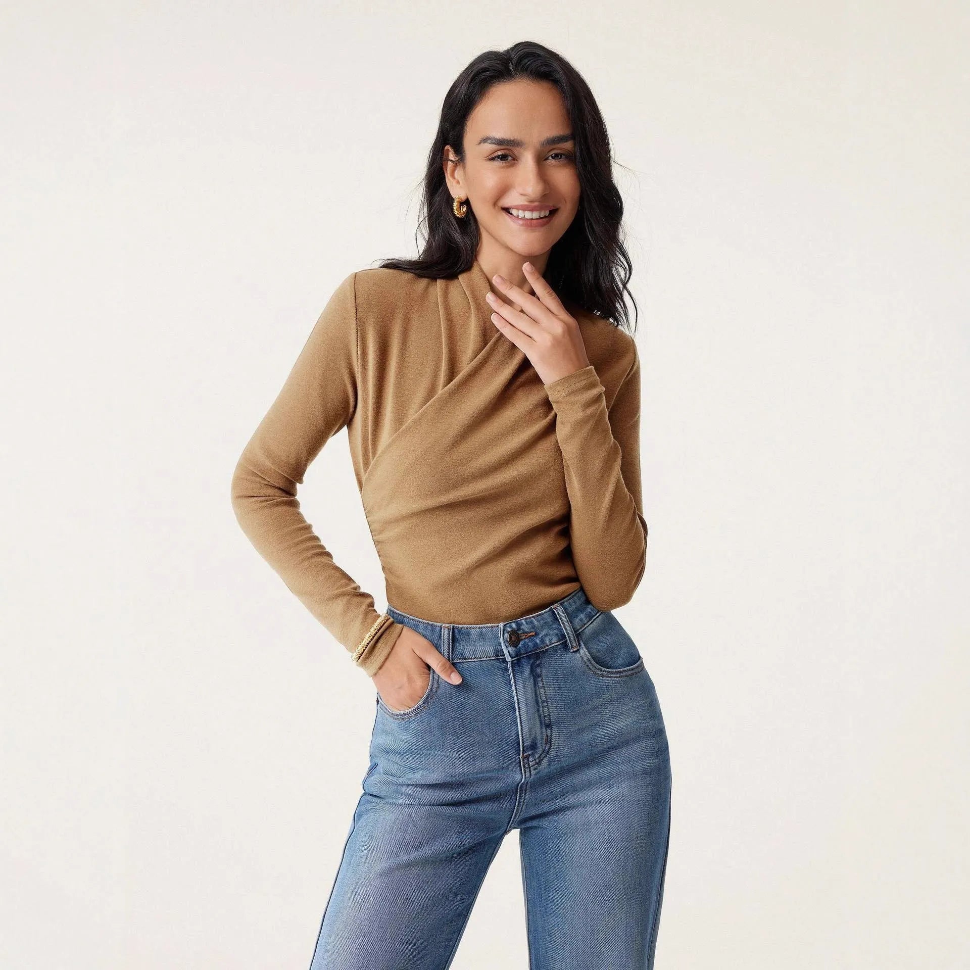 Camel coloured women's slim fit long sleeve pullover sweater on a hanger