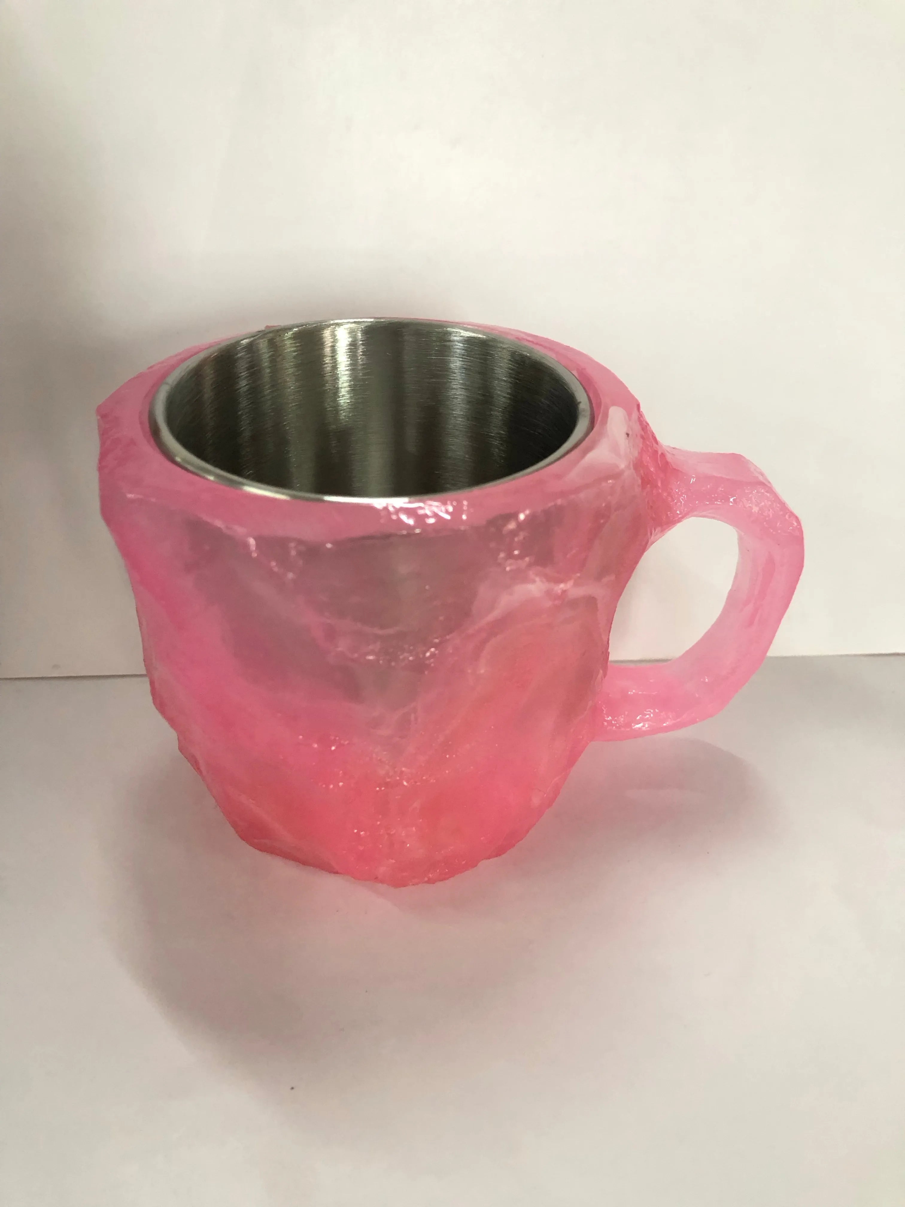 Purple and blue resin coffee mug with crystal texture and handle on wooden table