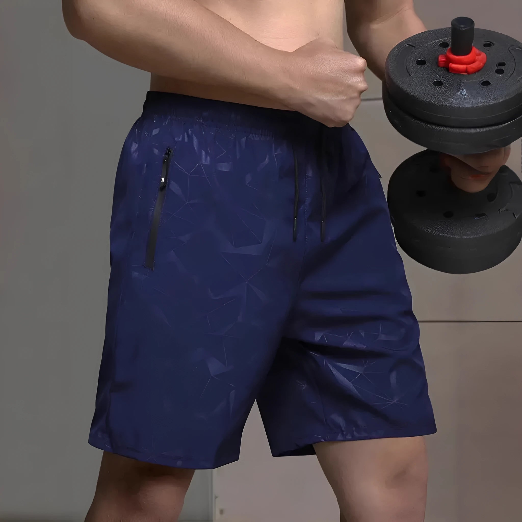 Man wearing loose fit black printed polyester sports shorts with elastic waistband on a beach.