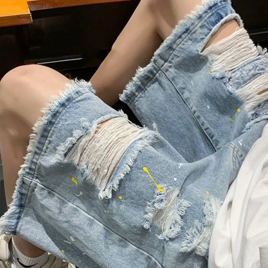 Men's loose fit water washed light blue denim shorts with hole details on a mannequin.