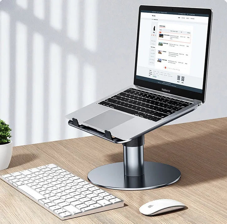 Silver adjustable laptop stand with 360-degree rotating base on a wooden desk.