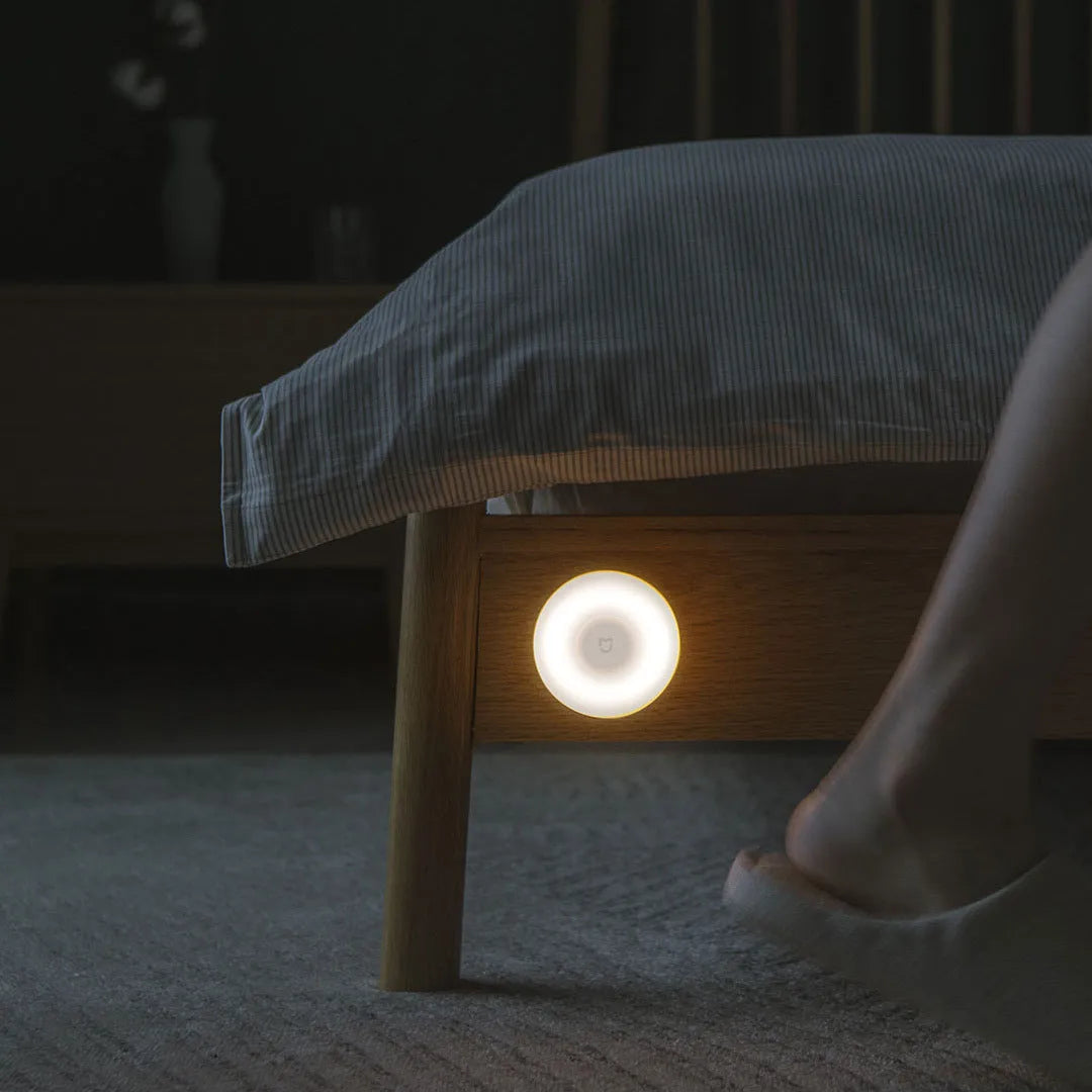 White square modern bedside table lamp with motion sensor and Bluetooth, shown on a nightstand.