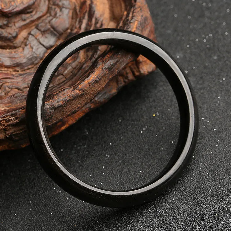 Obsidian cat's eye ethnic bracelet with geometric design on wrist, showing alloy and crystal construction.