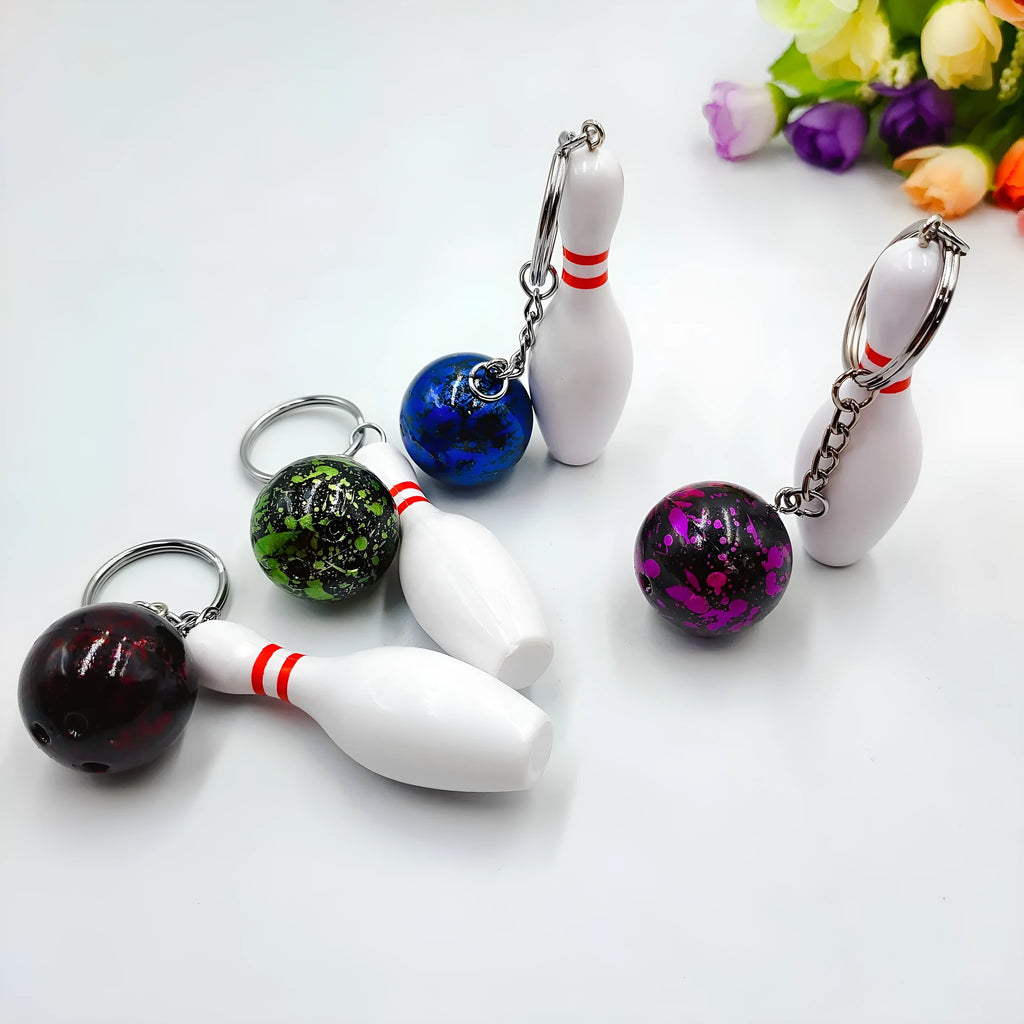 Mini bowling ball simulation keychain in blue, red, purple, and green colours.