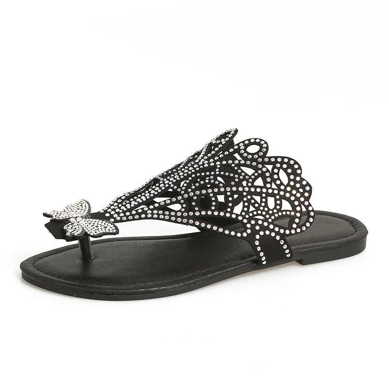 Black women's slip-on sandals with rhinestone detail and a flip-toe opening.