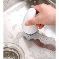 Orange and white radish-shaped nylon carrot cleaning brush for vegetables.