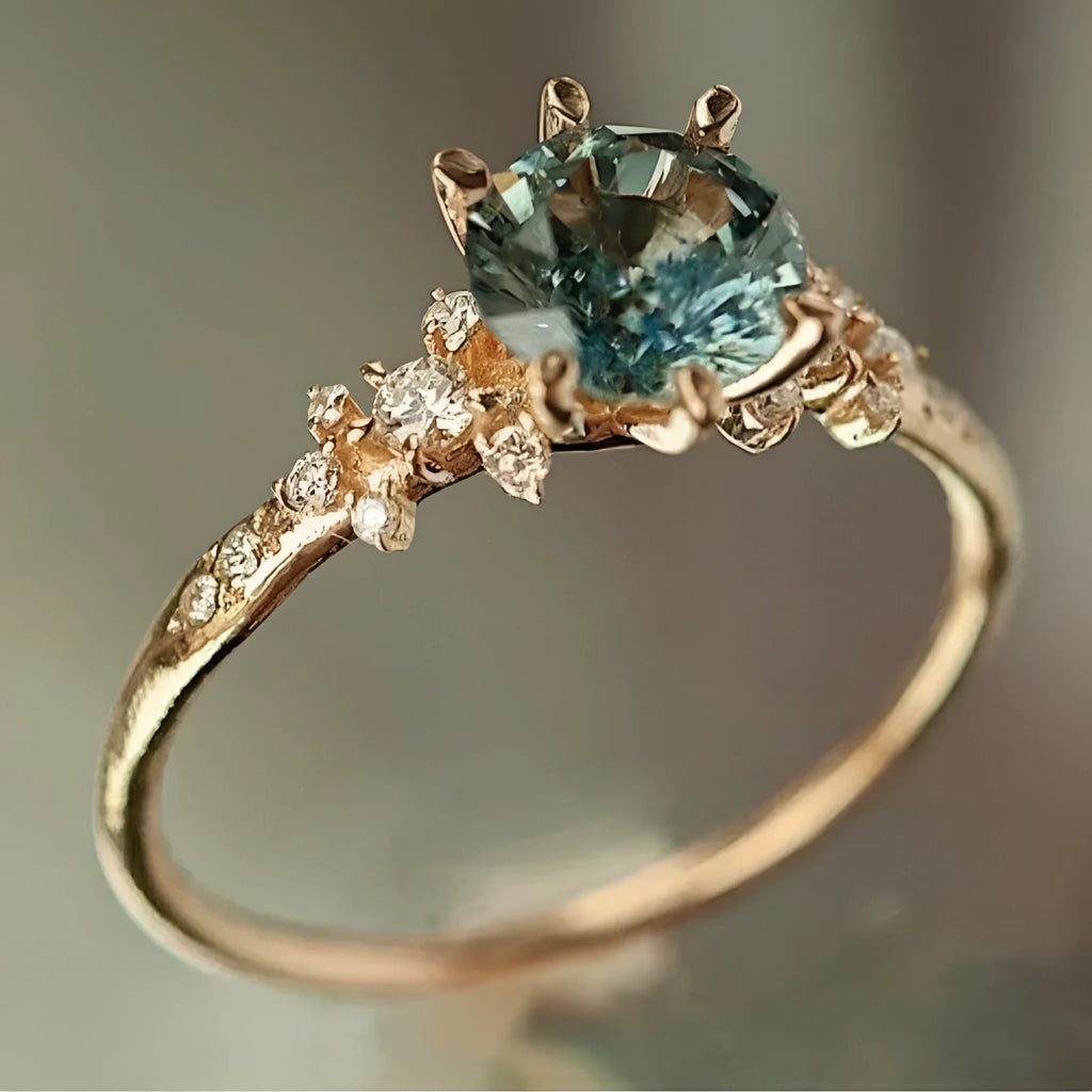 Gold geometric claw ring with inlaid zircon stones on a chamfered square band.