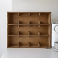 Solid square wood storage rack with multiple grid compartments for cups and mugs in birch wood colour.