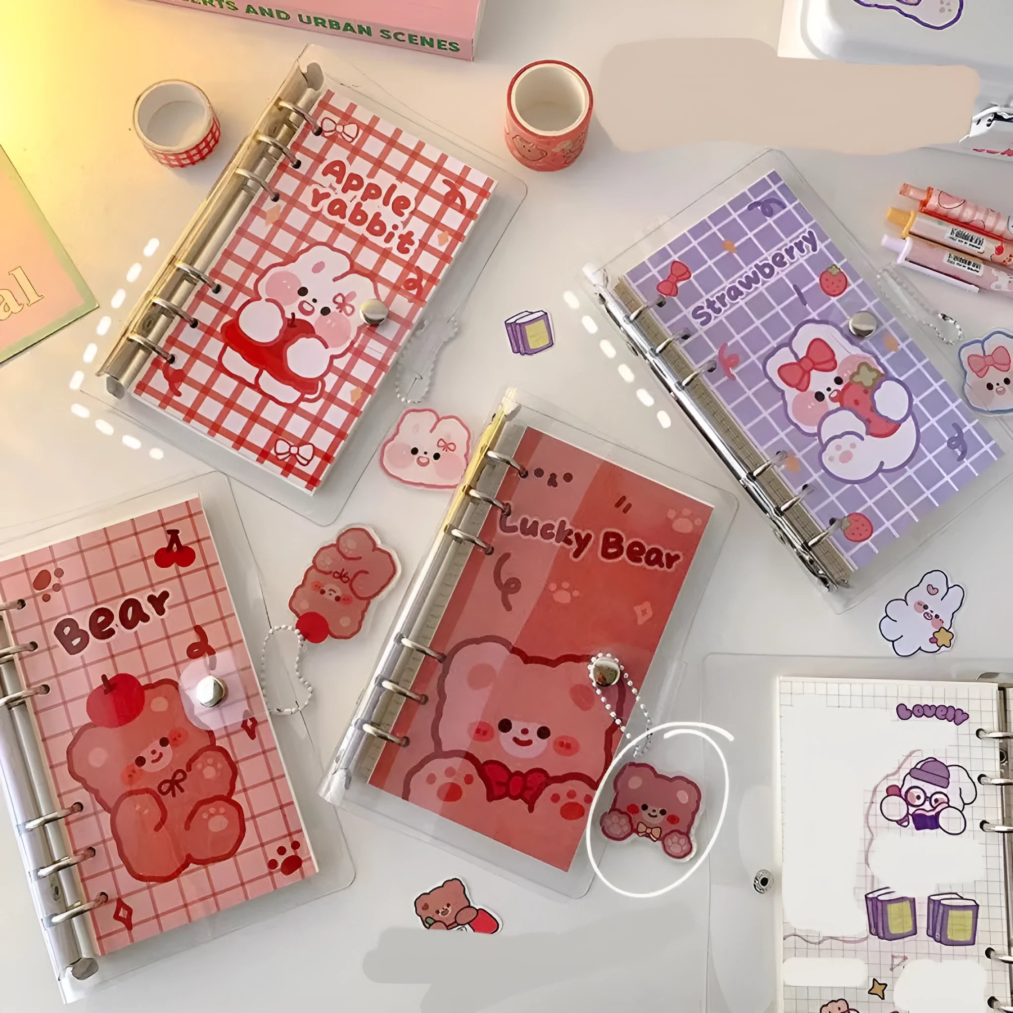 A6 size loose-leaf coil notebook with heart-themed bear design, showing coil binding and 6-hole edge.