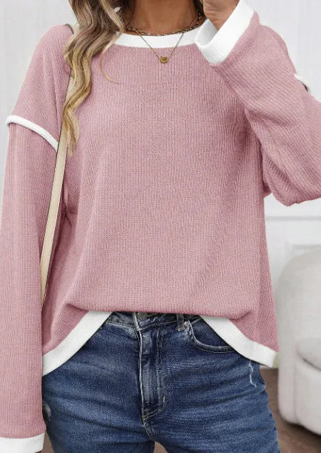 Loose fit beige knitted top with drop shoulders and contrast trim on a hanger.