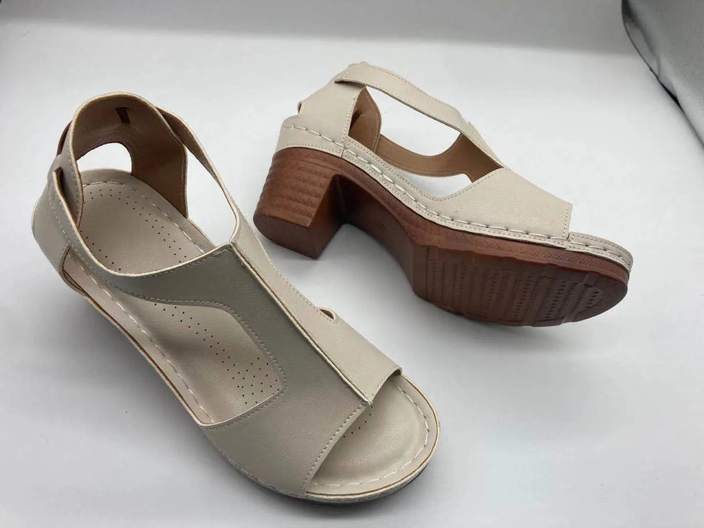 Women's white peep toe wedge sandals with Roman-style buckle ankle straps on a low heel.