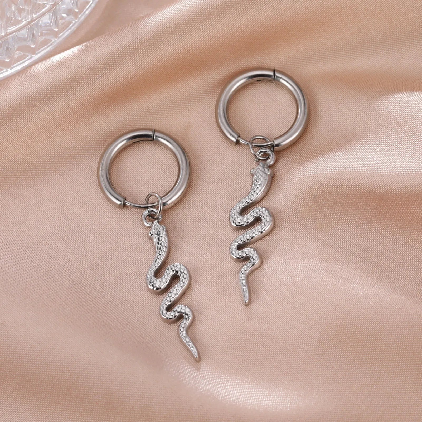 A pair of vintage-style snake-shaped earrings made from gold plated stainless steel with an ear clip fastening.