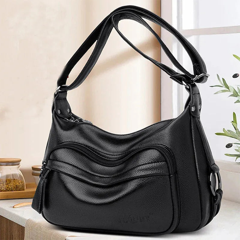 Large black women's shoulder bag with multiple compartments and luggage-inspired styling