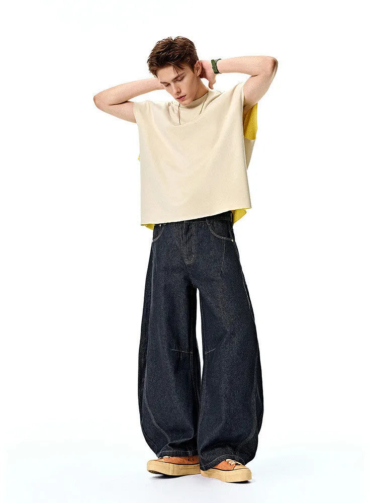 Men's wide leg denim trousers in original cow colour on a hanger, showing the relaxed fit and mid waist design.