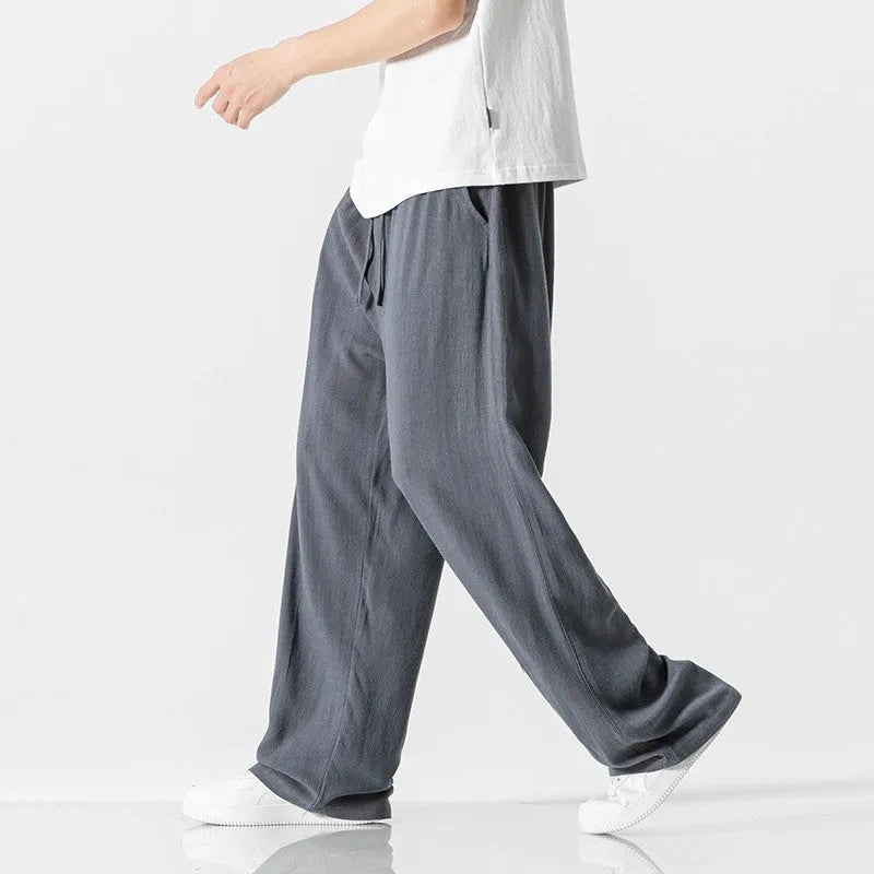 Men's beige bamboo fibre straight-leg cropped trousers with a drawstring waist on a neutral background.