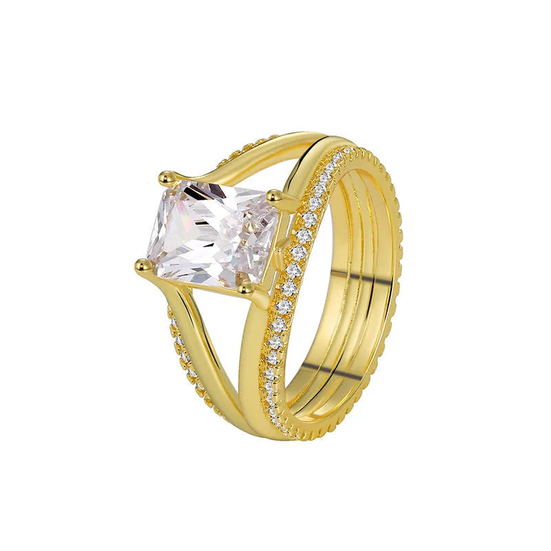 Gold-coloured geometric women's ring with a square zircon stone, shown on a finger.