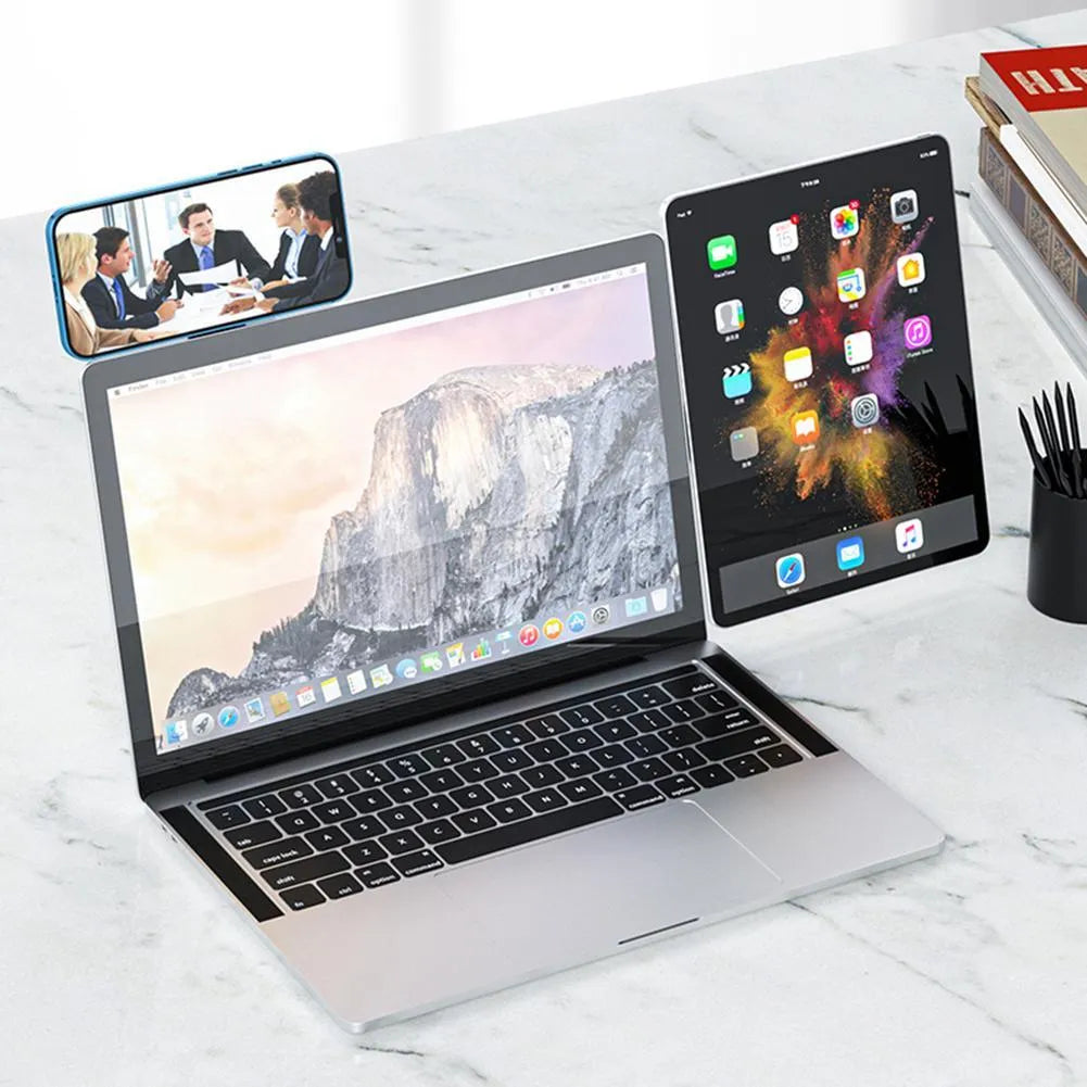 Black aluminium laptop phone holder with magnetic clip attached to a laptop screen, holding a smartphone.