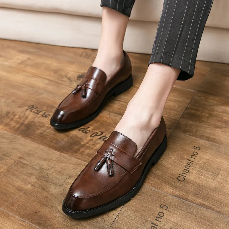 Men's black and brown tassel loafers with a slip-on design and rubber sole for business casual wear.