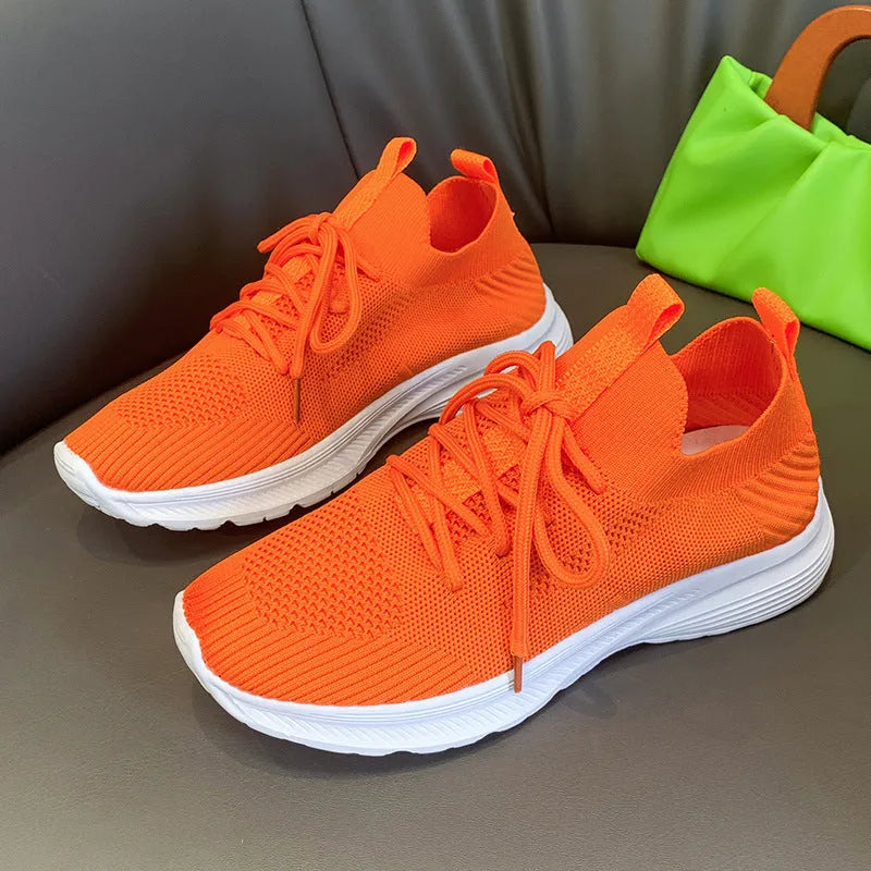 Women's low-top mesh breathable tennis shoes in creamy white, orange, and gray colours.