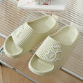 Green cat slippers with a thick EVA platform and non-slip sole on a wooden floor.