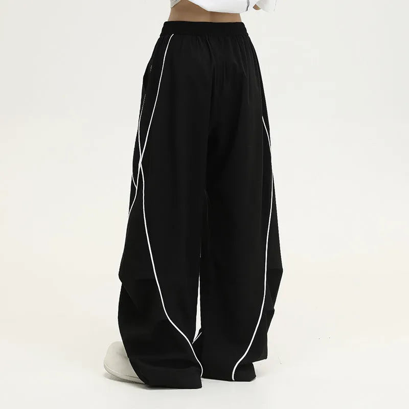 Black striped hip hop trousers with wide-leg pleated design showing mid-waist styling