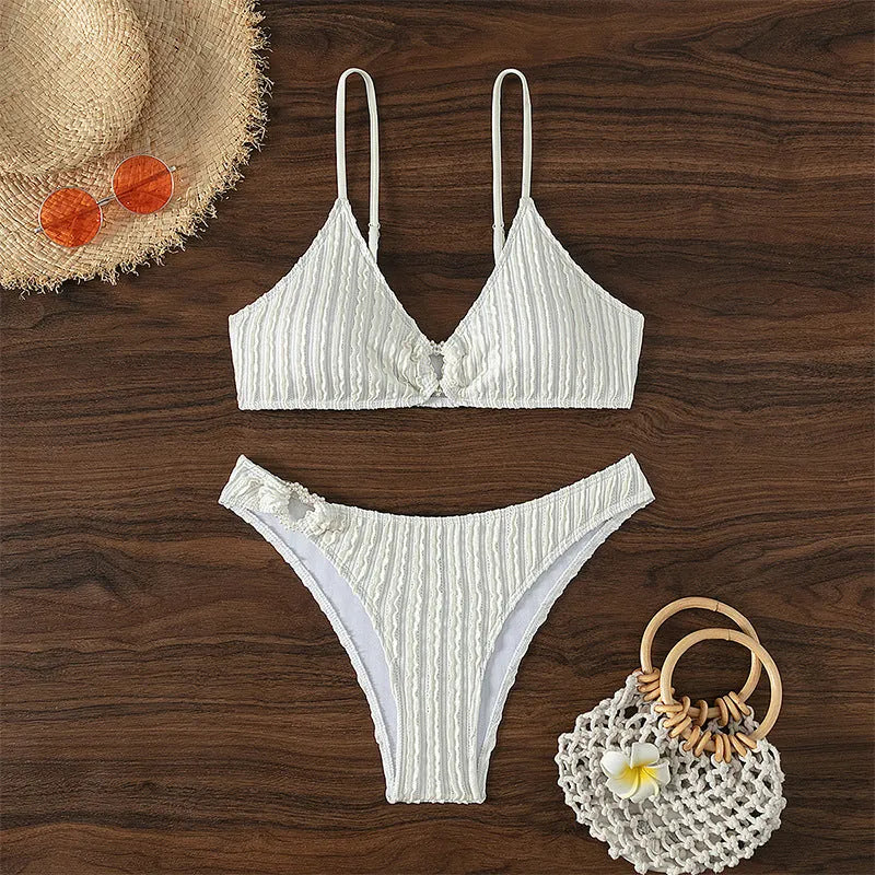White women's V-neck sleeveless swimsuit with split design on a beach