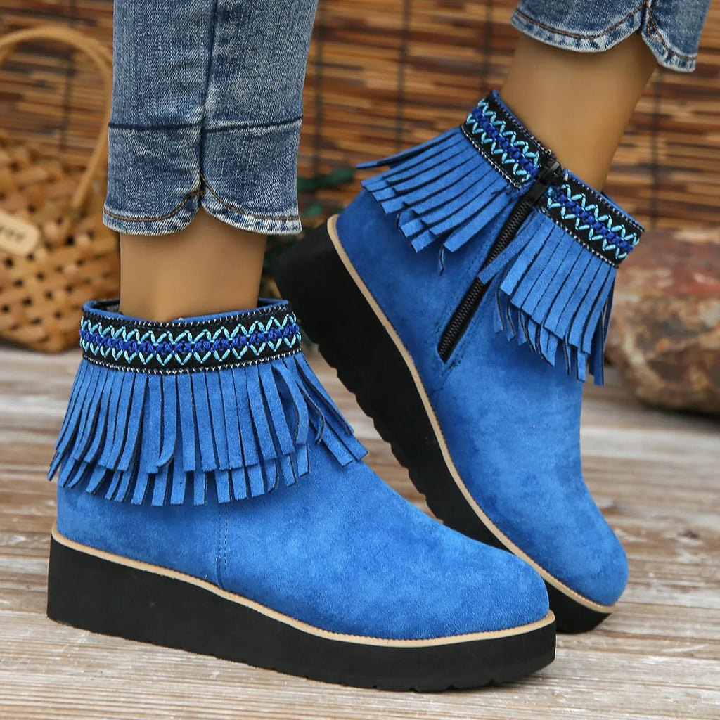 Women's suede ankle boot with wedge rubber sole, side zip, and tassel detail in dark brown.