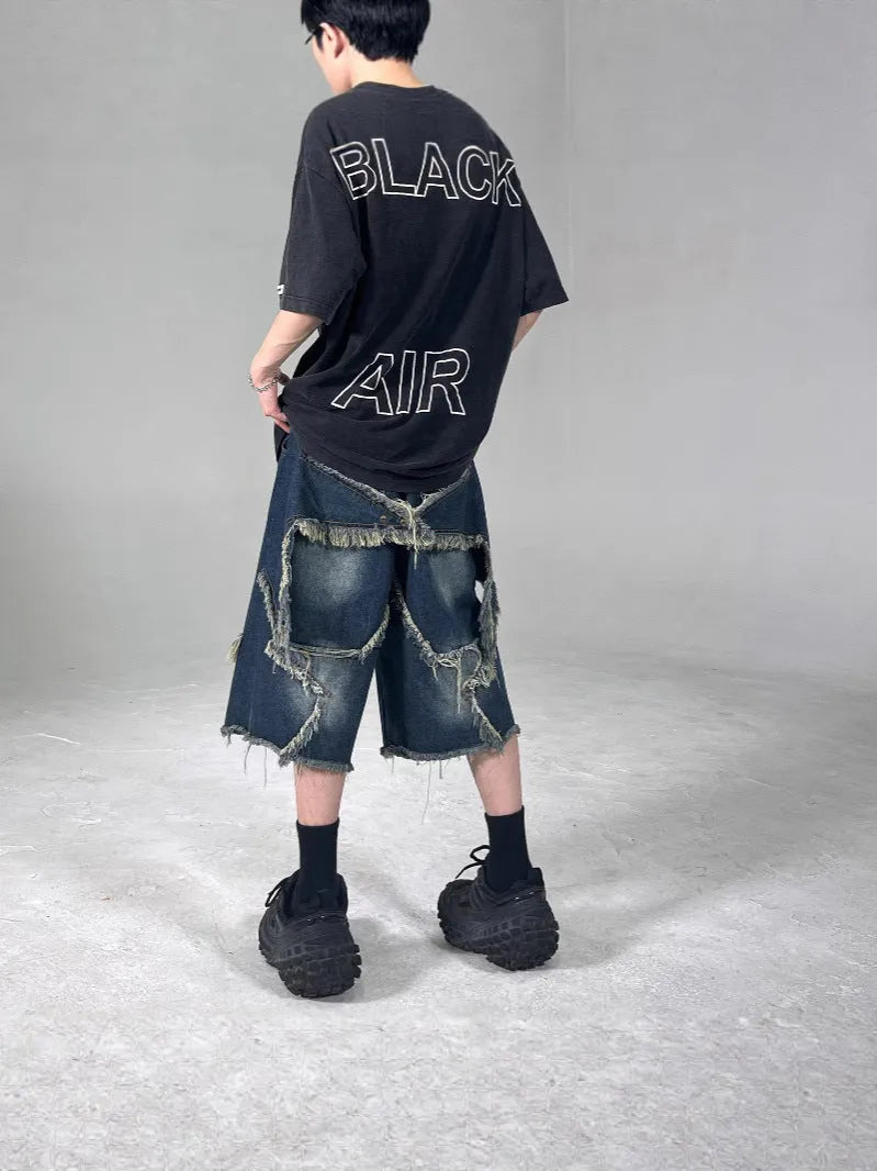 Blue cotton denim shorts for men with frayed hem detailing and five-pointed star patch, loose fit retro style