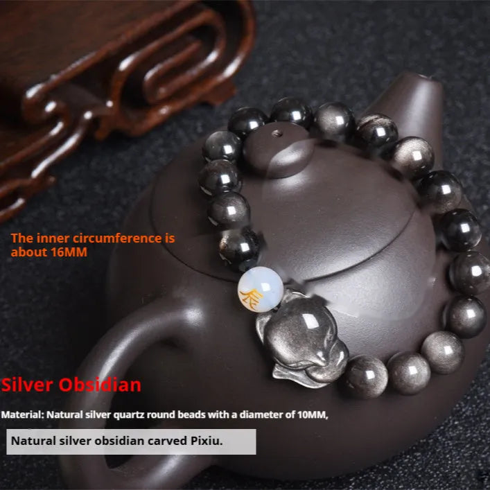 Natural black obsidian bracelet with 10mm beads on wrist, showing gold tone fastening option.