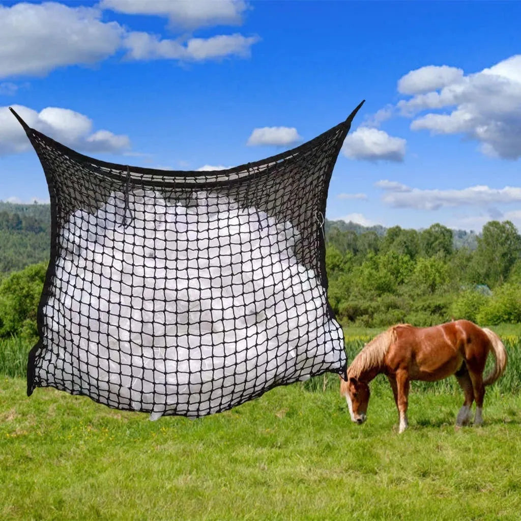 Black woven PE rope mesh feeding bag for horses hanging on a fence