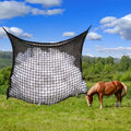 Black woven PE rope mesh feeding bag for horses hanging on a fence
