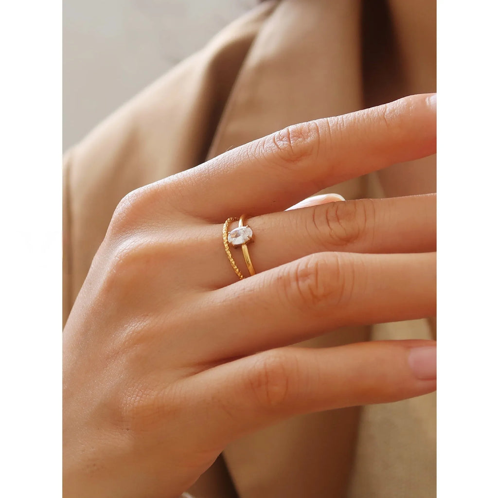 Gold electroplated stainless steel women's ring with heart design in oval shape on finger