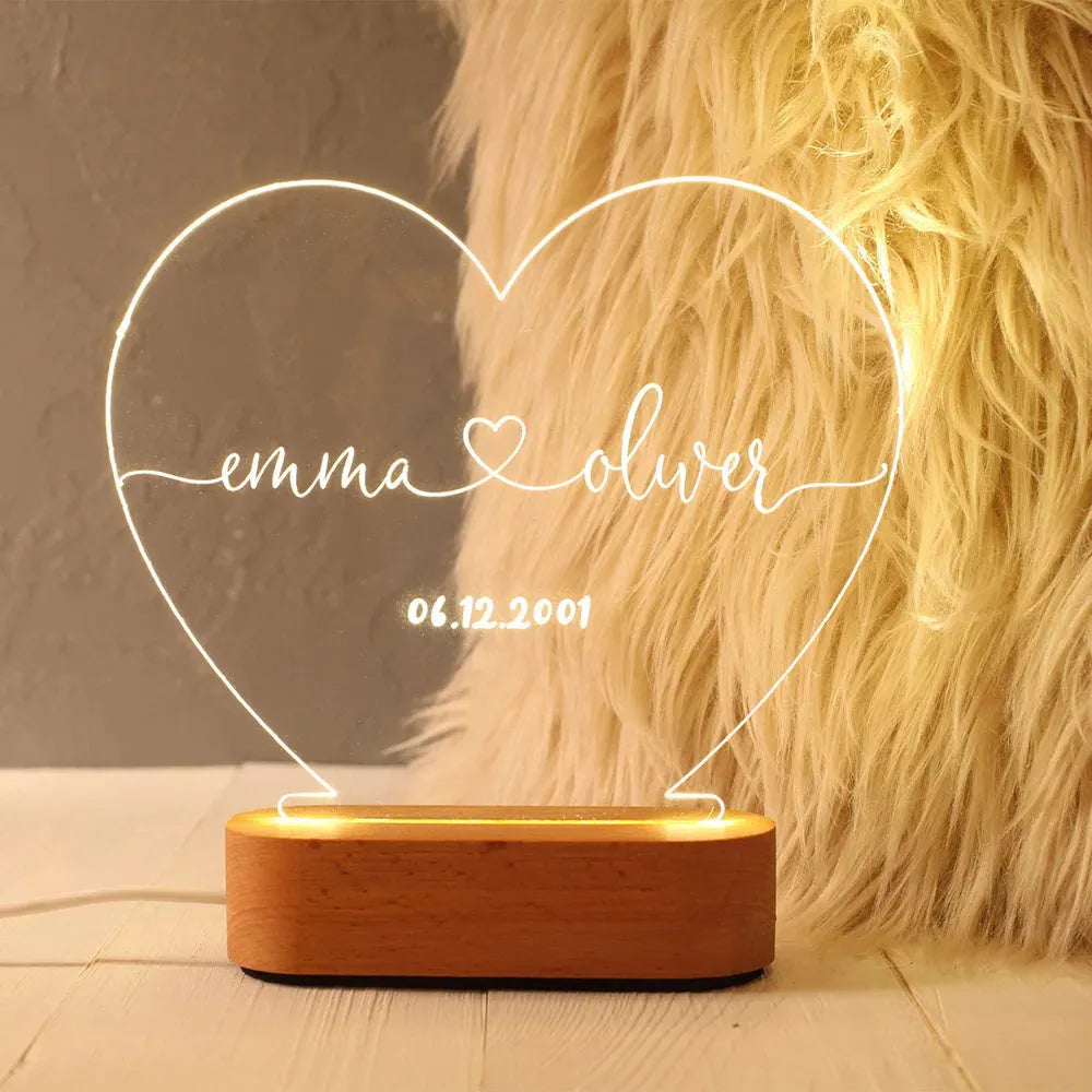Custom engraved acrylic night light displaying personal names and a date, lit from a base LED.
