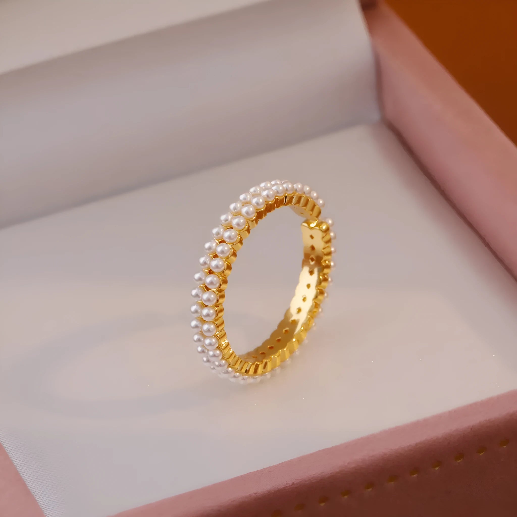 Gold geometric open ring for women with round pearls on a white background.