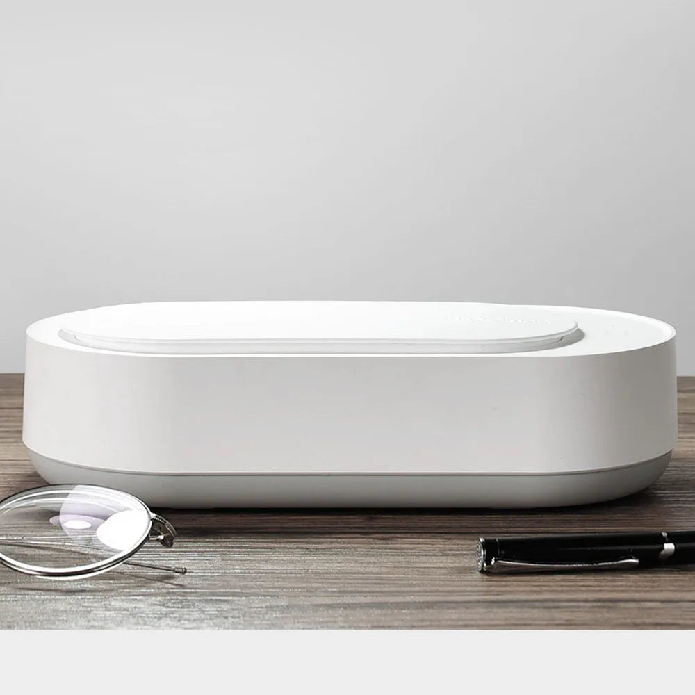 White portable ultrasonic cleaner with digital display and stainless steel cleaning tank.