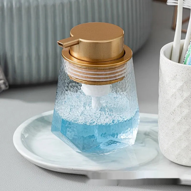 Foam pump bottle dispenser with large metallic pump head for facial cleanser.