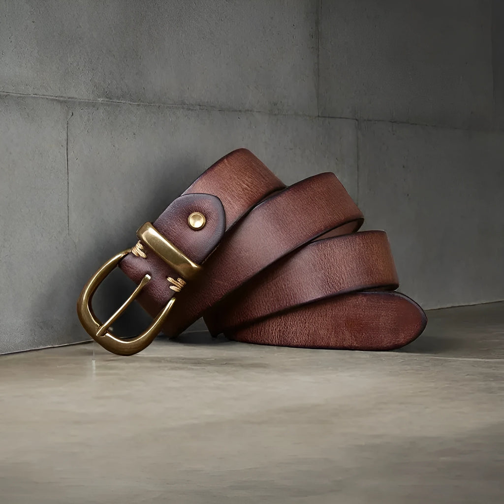 Men's black genuine leather casual belt with a copper pin buckle on a jeans background.