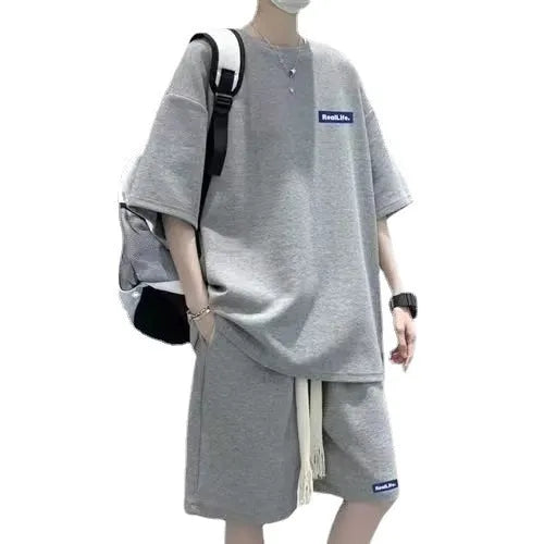Man wearing a grey waffle-textured cotton blend short sleeve top and matching shorts leisure set.