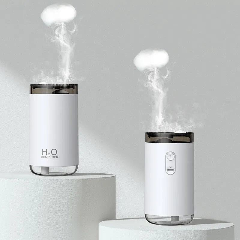 White jellyfish-shaped humidifier emitting smoke rings on a desk, with USB cable and warm glow.