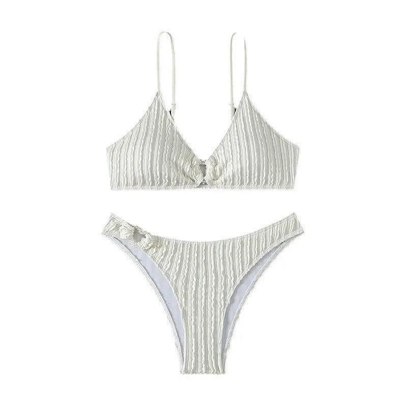 White women's V-neck sleeveless swimsuit with split design on a beach