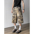 Yellow snake camouflage pattern on cropped denim jeans laid flat.