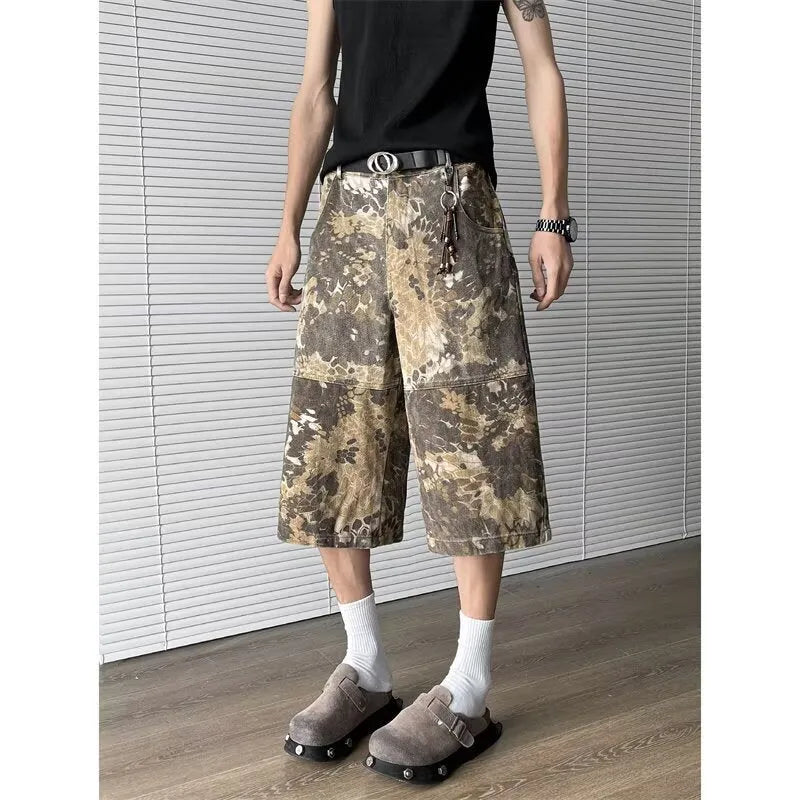 Yellow snake camouflage pattern on cropped denim jeans laid flat.