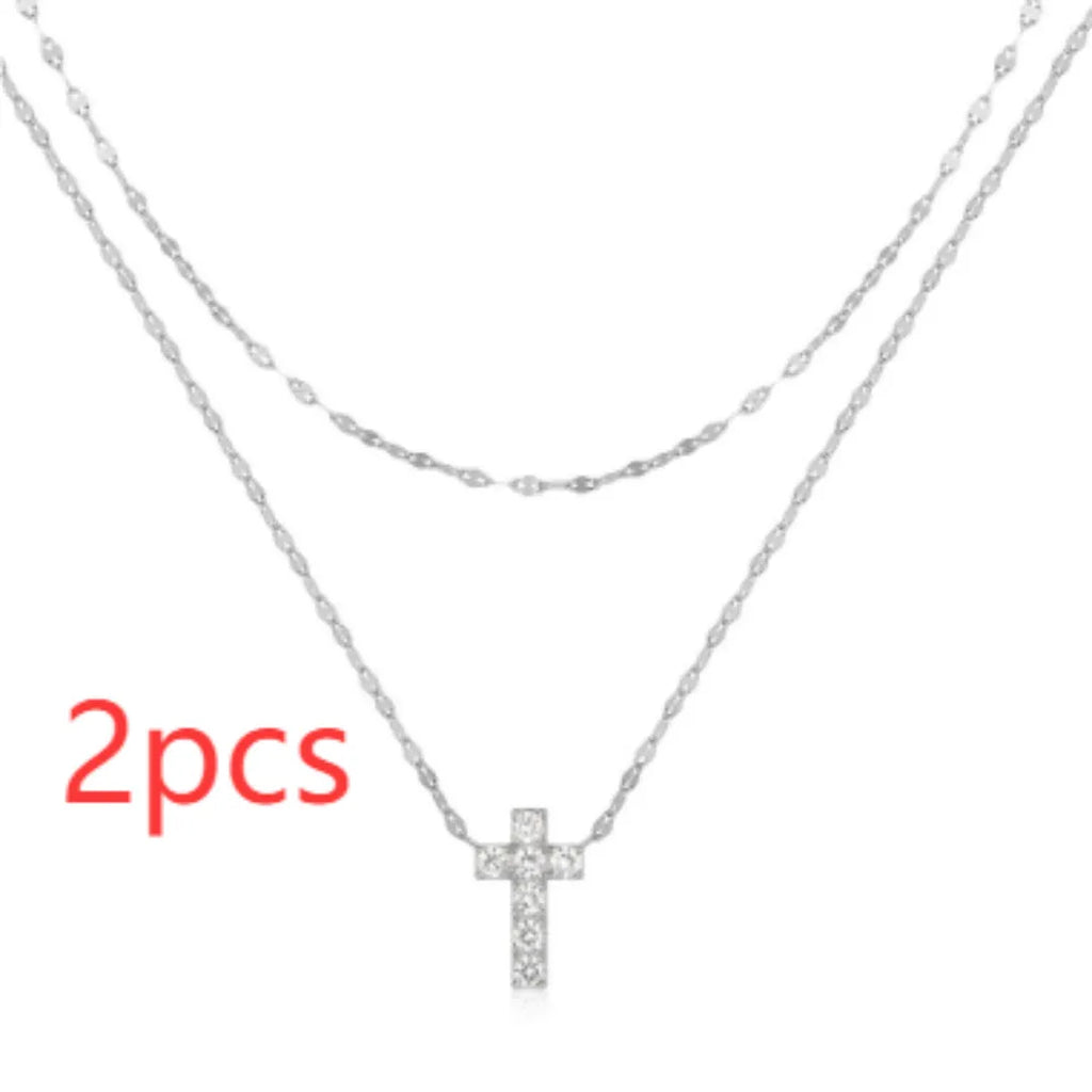S925 sterling silver double layer twin diamond cross pendant on a clavicle chain, shown in gold and white gold finishes.