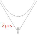 S925 sterling silver double layer twin diamond cross pendant on a clavicle chain, shown in gold and white gold finishes.