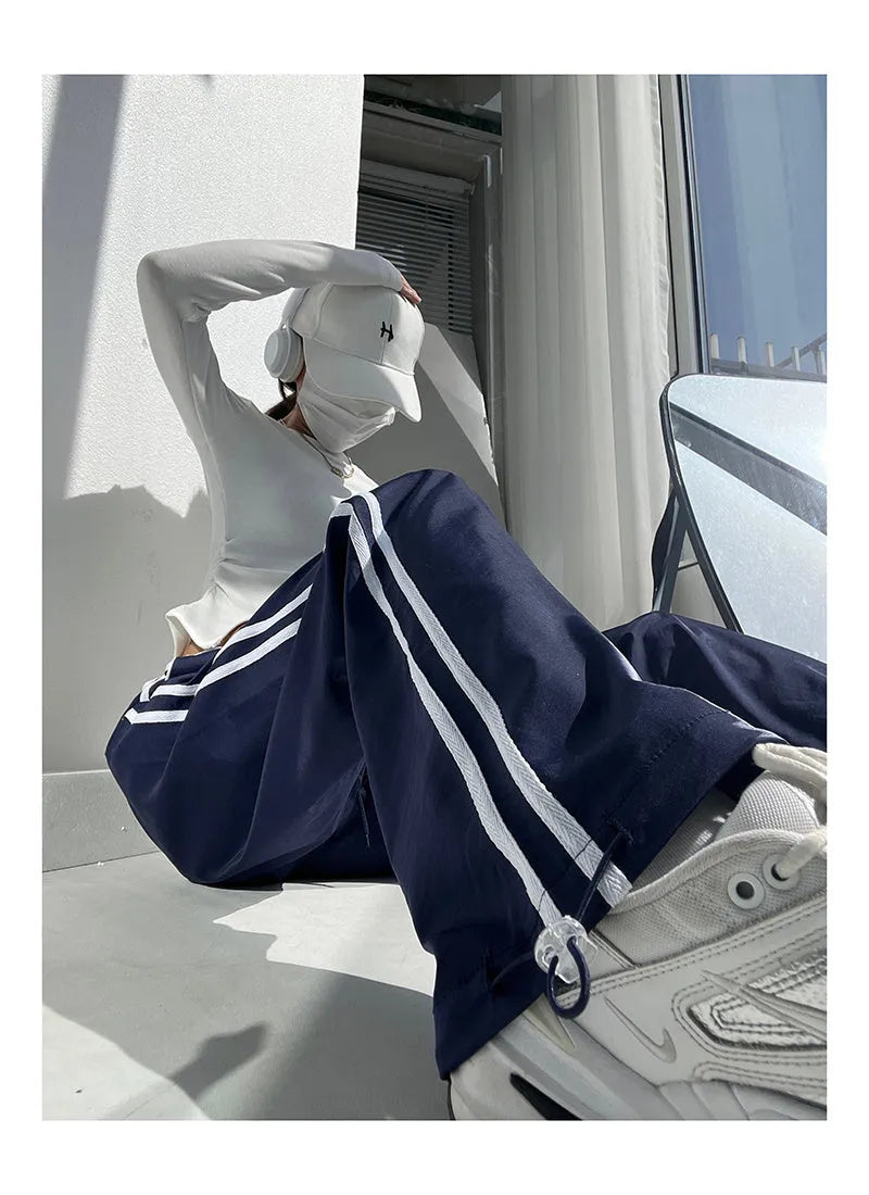Navy blue loose straight leg drape pants with a low waist and thin fabric, laid flat.