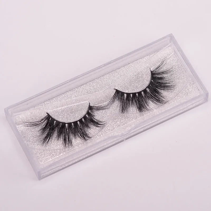 Handmade 5D mink false eyelashes set with storage case and double-headed brush on a clean background.