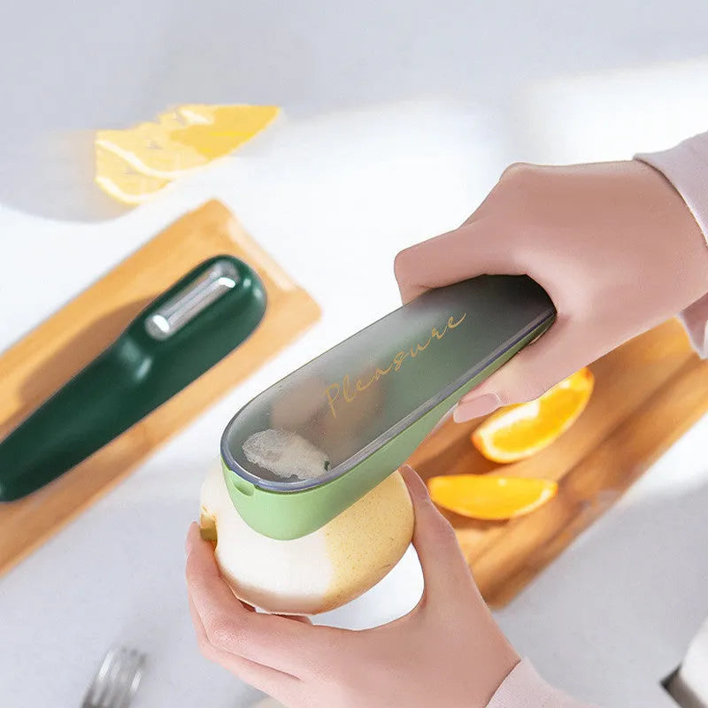 Green vegetable and fruit peeler with a storage tube and stainless steel blade on a kitchen counter.