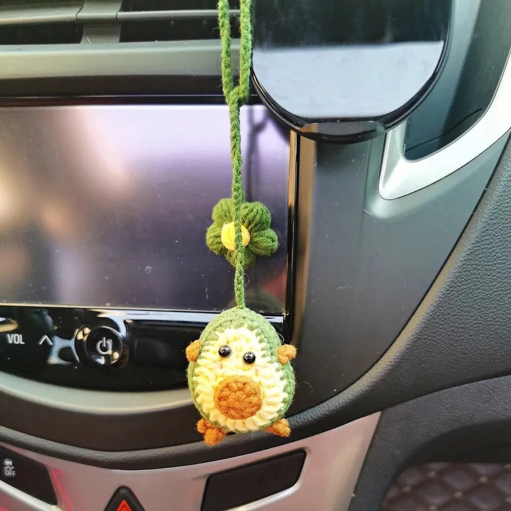 Handmade crocheted wool car pendant with a cartoon flower in avocado, pink rainbow, or red rainbow colours.