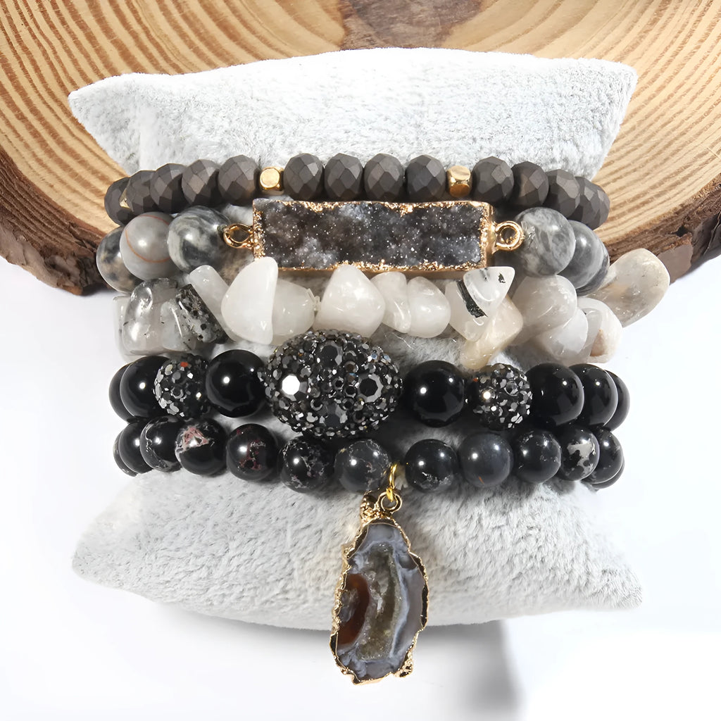 Set of five handmade stretch bracelets with glass, crystal, and hematite beads in irregular shapes on a neutral background